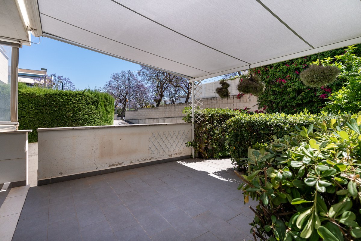 Covered terrace with electric awning and garden view