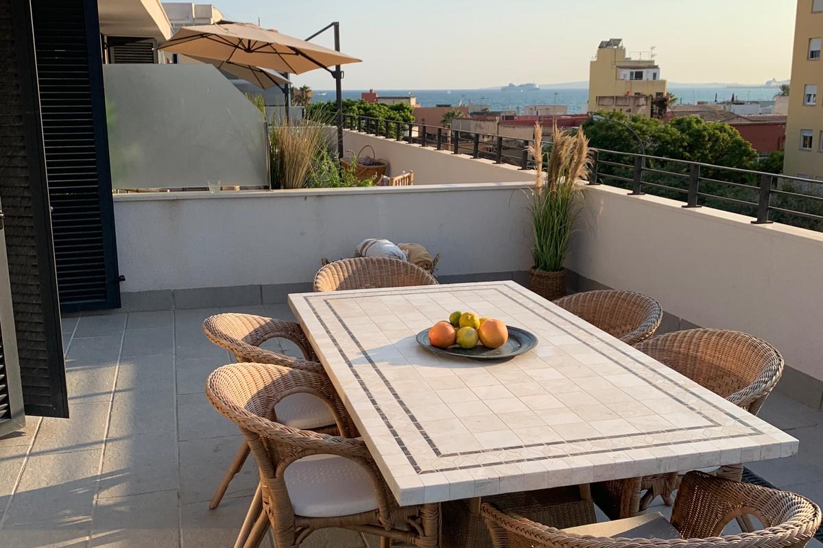 Wraparound terrace dining with sea views at sunset