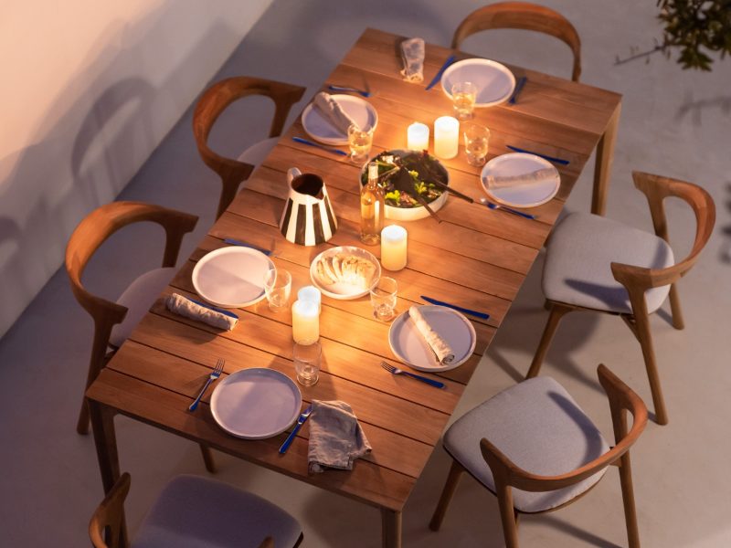 A long wooden dining table laid for dinner