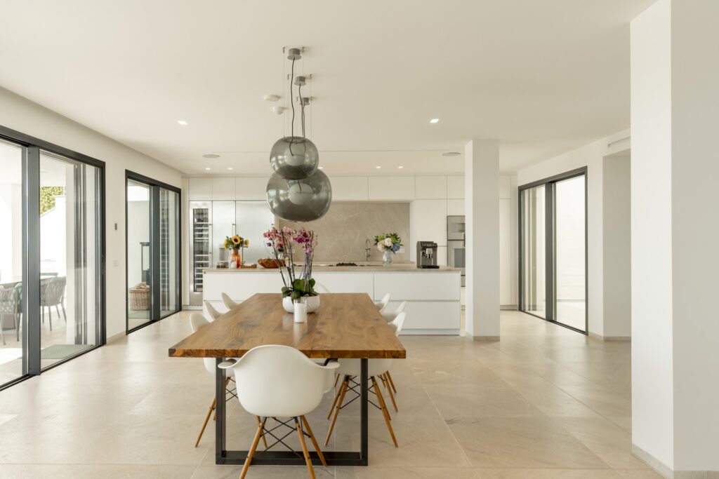 Long dining table under glass pendant lights