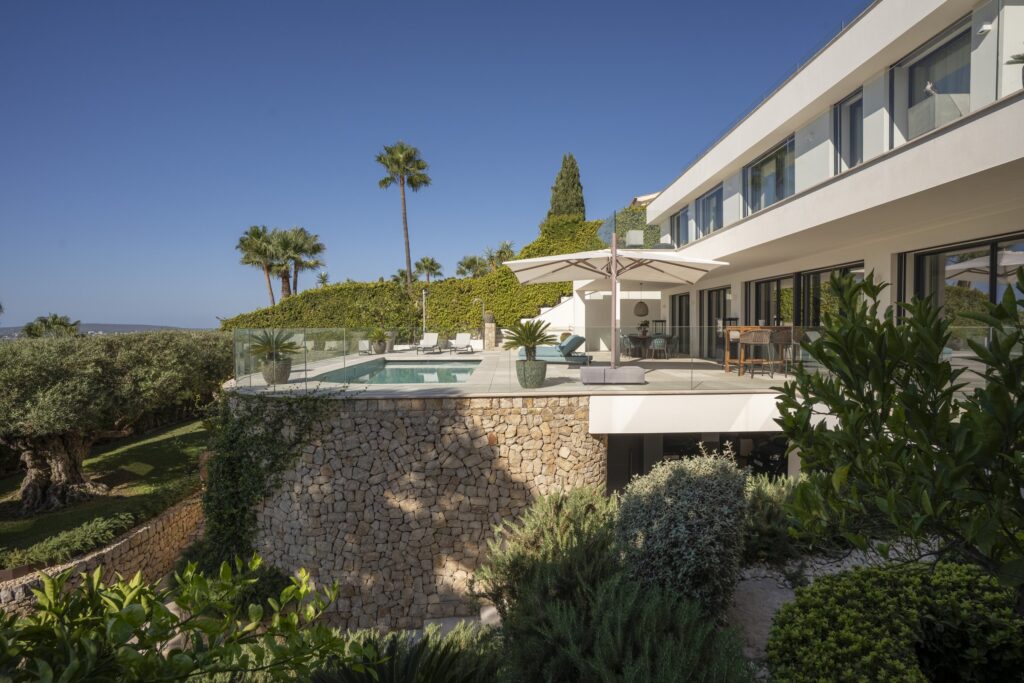 The villa above its planted garden and stone walls