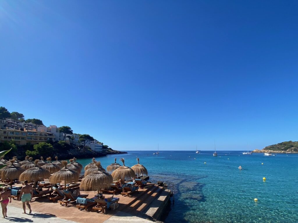 Parasols above the clear water at Sant Elm
